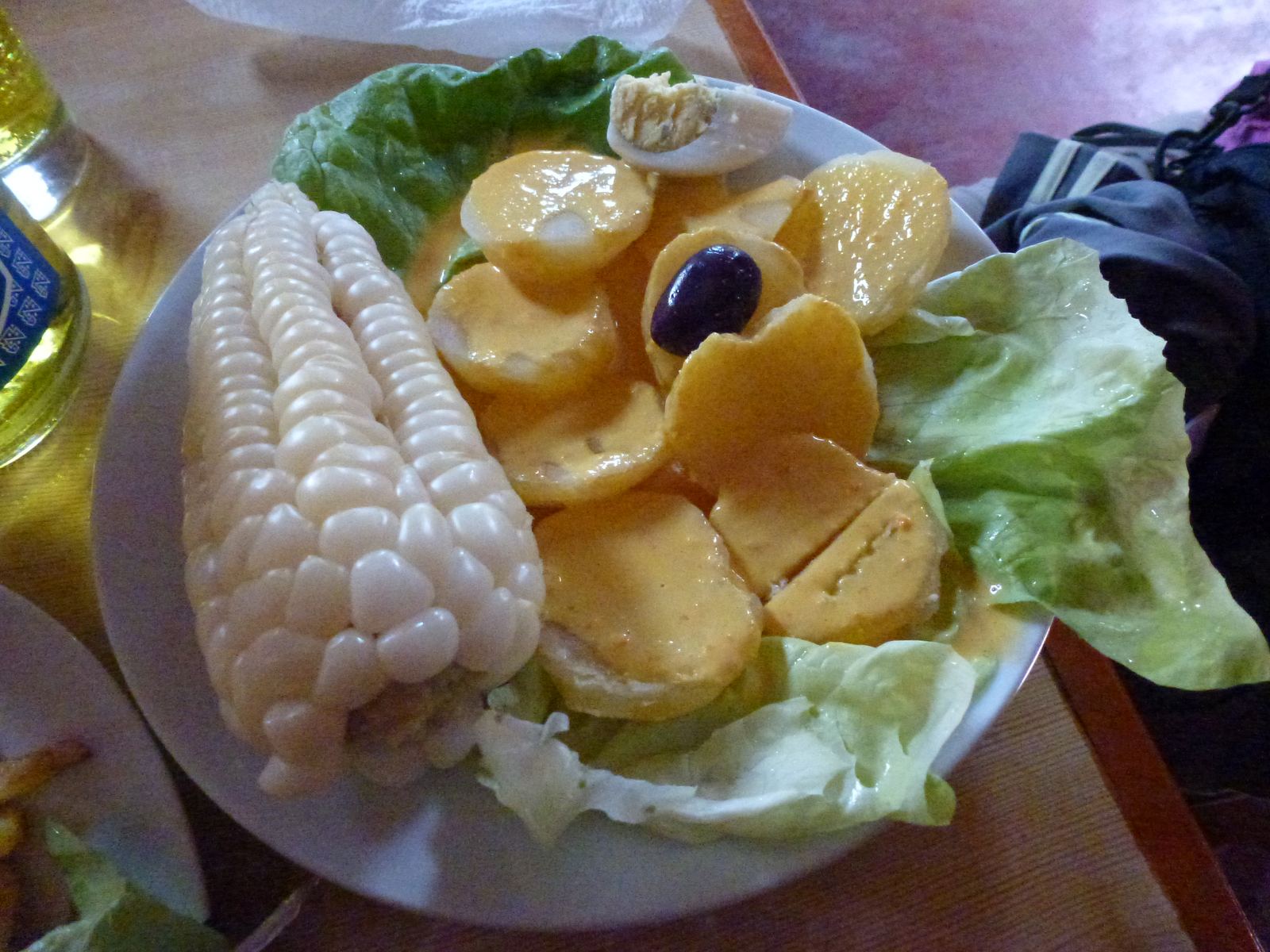 Sliced yellow potatoes in creamy huancaína sauce with corn, egg and lettuce